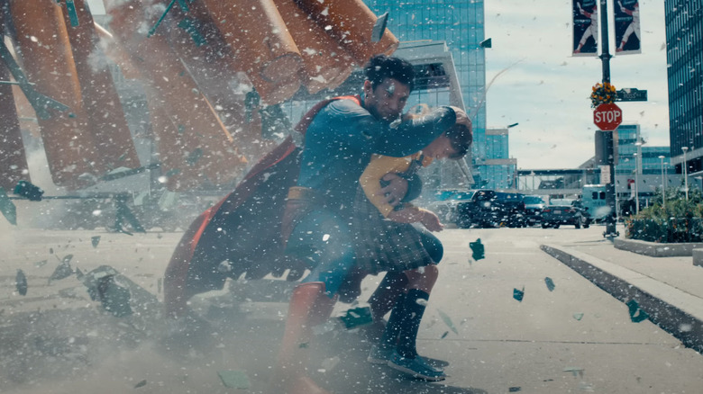 Superman swooping in to protect a child from falling debris in Superman