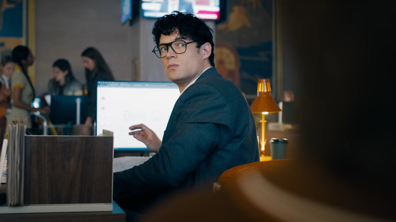 Clark Kent in glasses turning around at his desk at the Daily Planet in Superman