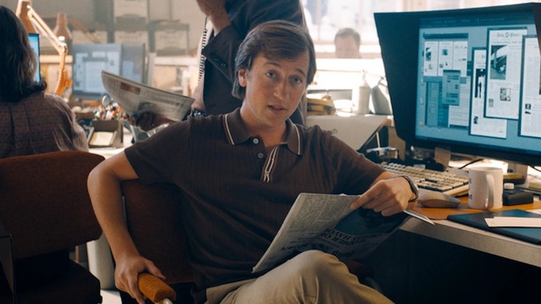 Skyler Gisondo's Jimmy Olsen holding a newspaper and sitting in Superman