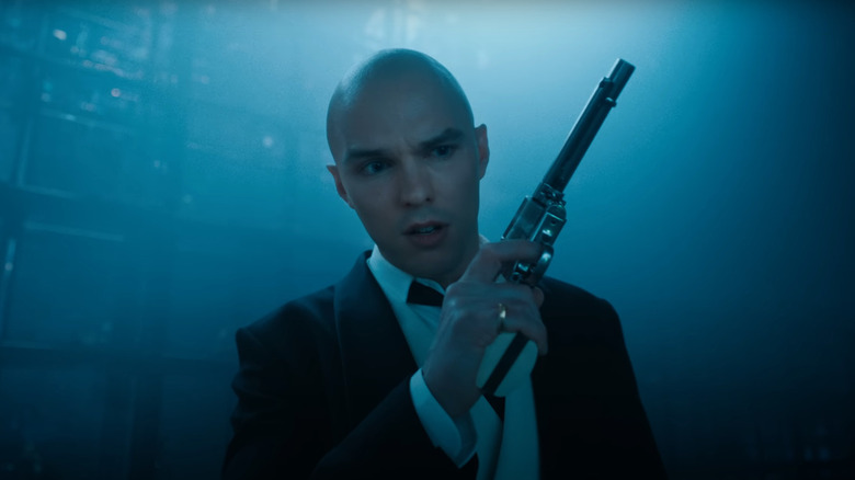 Nicholas Hoult as Lex Luthor in a tuxedo and with a gun in Superman