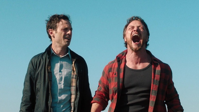 James McAvoy's Paddy screams against a blue sky background as Scoot McNairy's Ben Dalton watches in Speak No Evil
