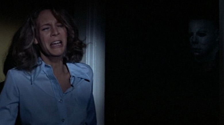 Halloween's Laurie hides from Michael in hallway