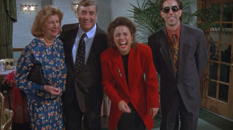Elaine (Julia Louis-Dreyfus), Jerry Seinfeld, Morty (Barney Martin), and Helen (Liz Sheridan) all pose for a picture in Seinfeld