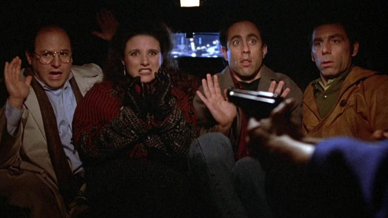 George, Elaine, Kramer e Jerry, sentados atrás da limusine com uma arma para ver a arma