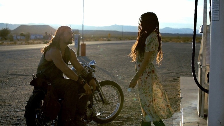 Jason Momoa as Robert Wolf sitting on his motorcycle talking to a girl at the gas station in Road to Paloma