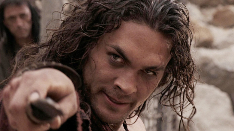 Jason Momoa as Conan pointing a knife in Conan the Barbarian (2011)