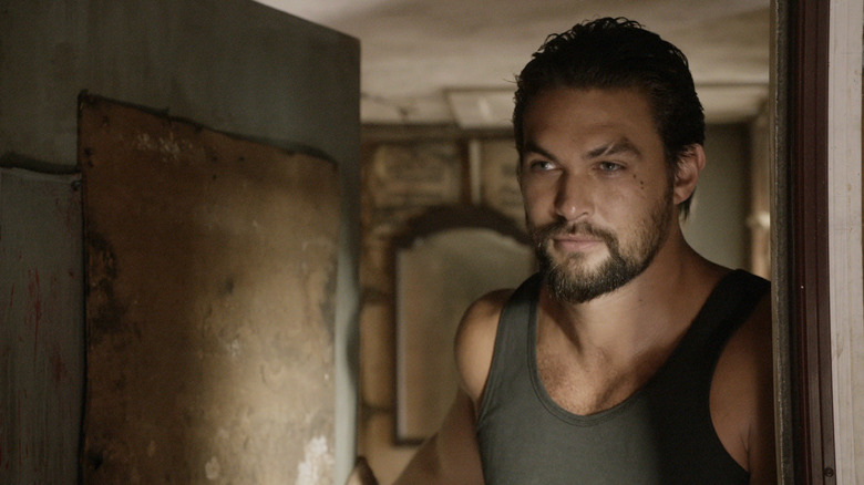 Phillip Kopus van Jason Momoa kijkt uit een deur in The Red Road