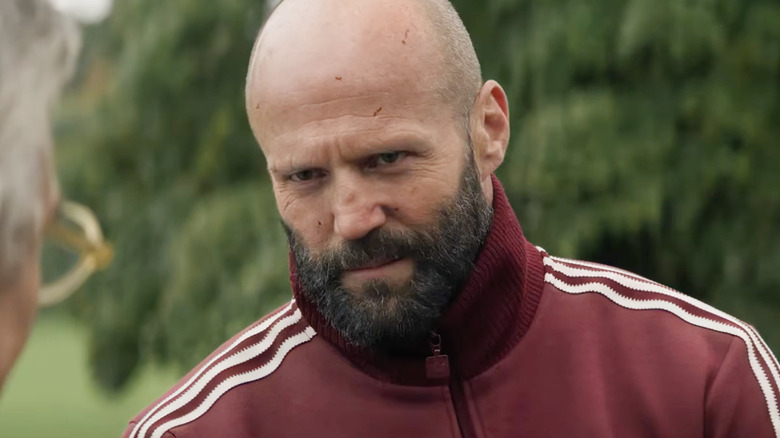 Adam Clay wearing a red track suit in The Beekeeper 2