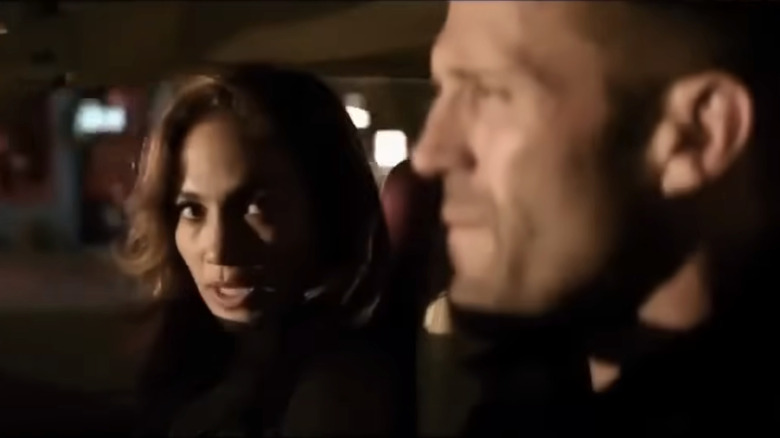 Jennifer Lopez's Leslie Rodgers sits in the passenger seat of a car looking across at Jason Staham's Parker in Parker