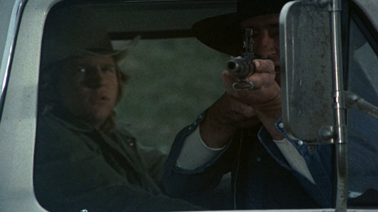 Jeff Bridges' Jack McKee watches as Sam Waterston's Cecil Colson aims a rifle out of a car window in Rancho Deluxe