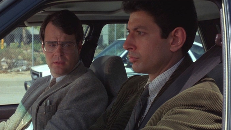 Jeff Goldblum as Ed Okin sits glumly in his car next to Dan Aykroyd as Herb in Into the Night
