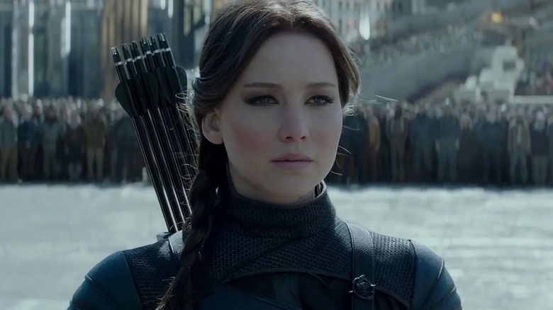 Jennifer Lawrence as Katniss Everdeen standing in front of a massive crowd in The Hunger Games: Mockingjay - Part 2