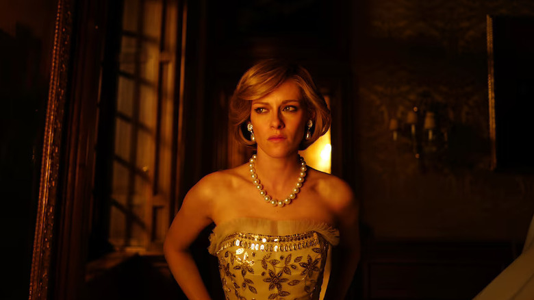 Diana in a gown by a window looking tearful in Spencer