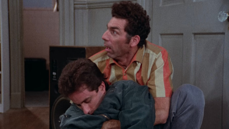 Kramer segura um Jerry em suas mãos Seinfeld