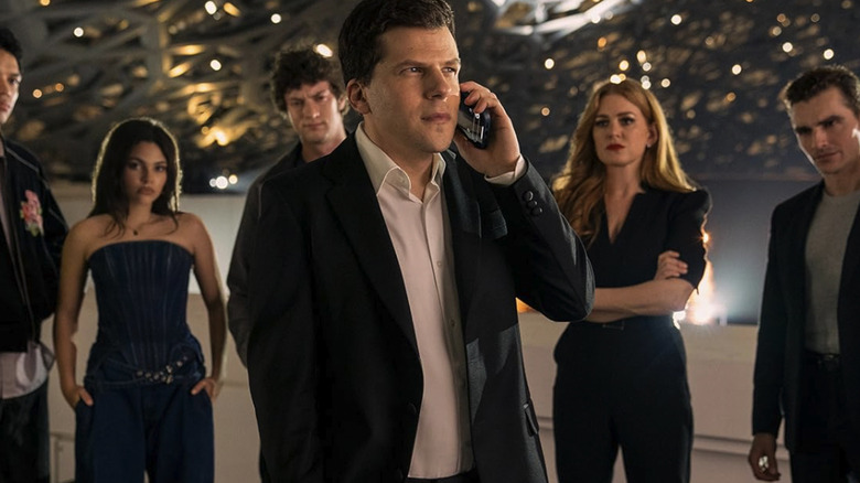 J. Daniel Atlas on the phone with other magicians standing behind him in Now You See Me: Now You Don't