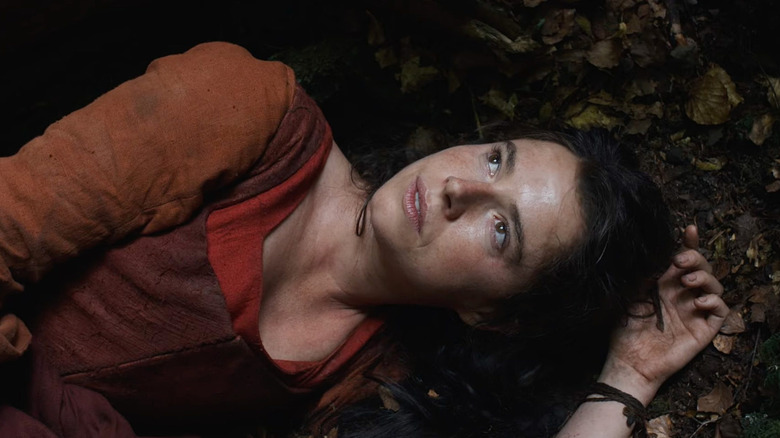 Jessie Buckley as Agnes laying in the dirt in Hamnet