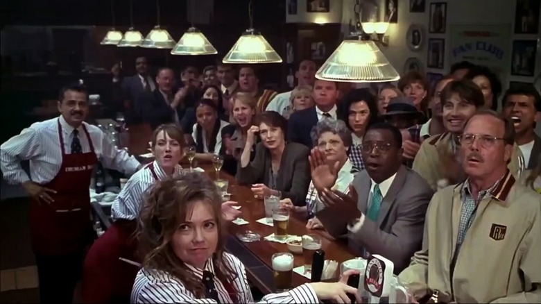 crowd at bar watches TV The Truman Show