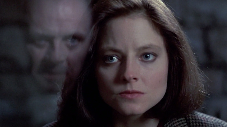 Jodie Foster as Clarice Starling looking at Anthony Hopkins as Hannibal Lecter, who is reflected in the glass between them, in The Silence of the Lambs