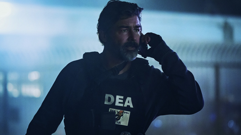 Kyle Chandler's DEA agent talks to someone on the phone in The Rip