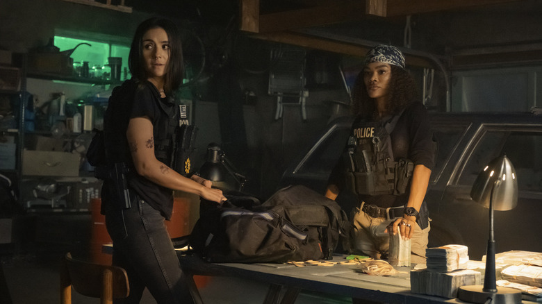 Teona Taylor and Catalina Sandino Moreno pack money into a black duffel bag in The Rip