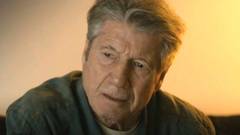 Fred Ward as Eddie Velcro sitting down in True Detective