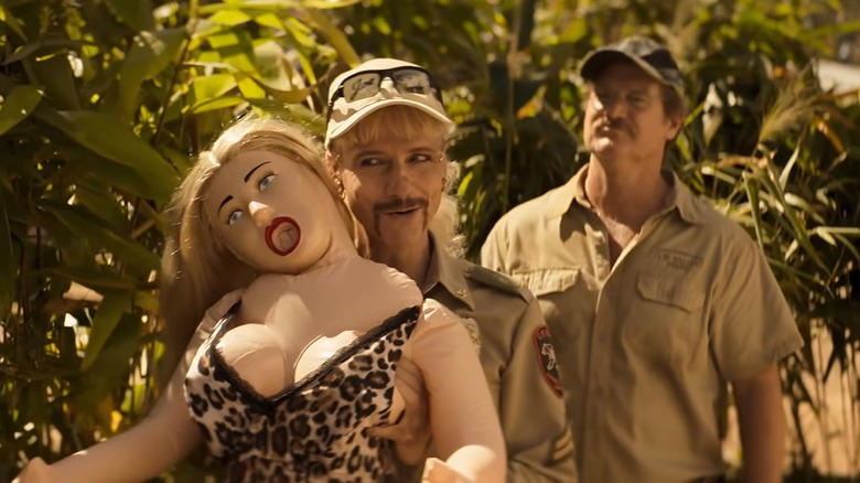 john cameron mitchell as joe exotic holding a blowup doll