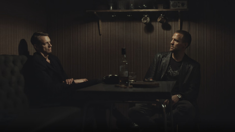 Joel Kinnaman's Tom Waaler sits at a table with Tobias Santelmann's Harry Hole in Jo Nesbø's Detective Hole
