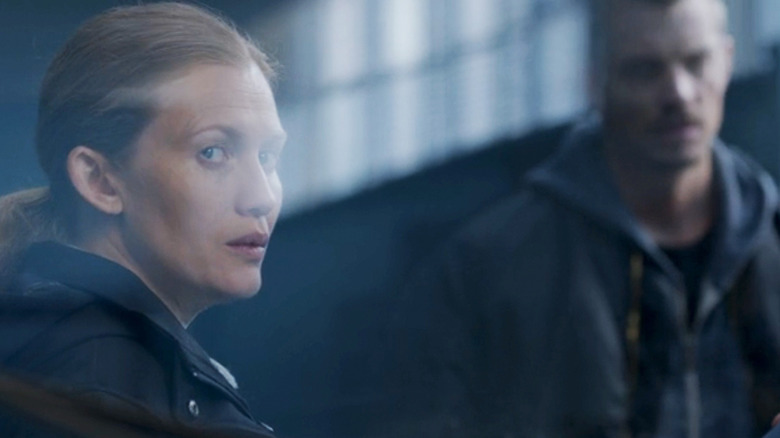 Joel Kinnaman's Stephen Holder stands in the background as Mireille Enos' Sarah Linden is seen through a window in The Killing .jpg