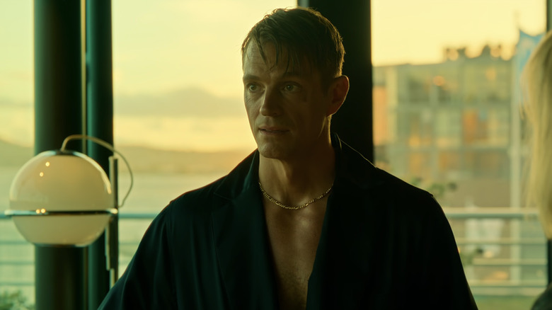 Joel Kinnaman's Tom Waaler stands by the window of his apartment in a robe in Jo Nesbø's Detective Hole