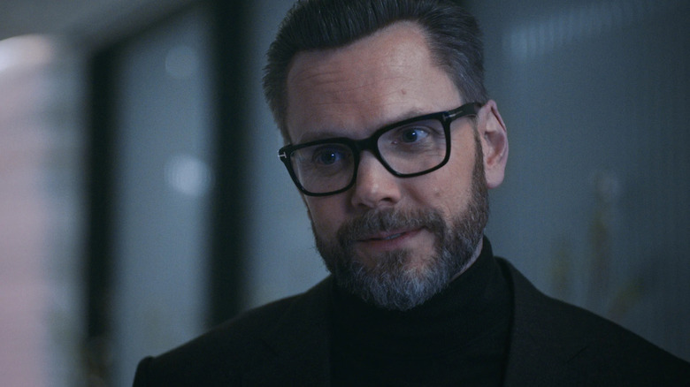 David Fields (Joel Macheel) has an arrogant expression and wears elegant black collar and glasses in the bear