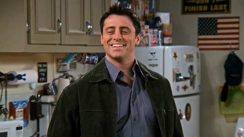 Matt LeBlanc's Joey smiles while standing in his apartment in Friends