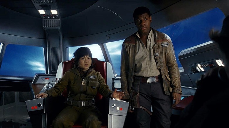 Kelly Marie Tran as Rose Tico sitting in a cockpit chair while John Boyega as Finn stands beside her in Star Wars: The Last Jedi