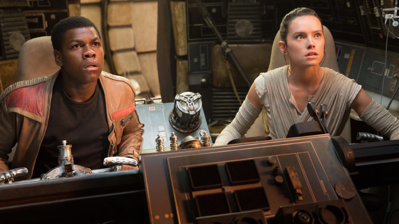 Finn (John Boyega) and Rey (Daisy Ridley) sit in the cockpit of the Millennium Falcon in "Star Wars: The Force Awakens"