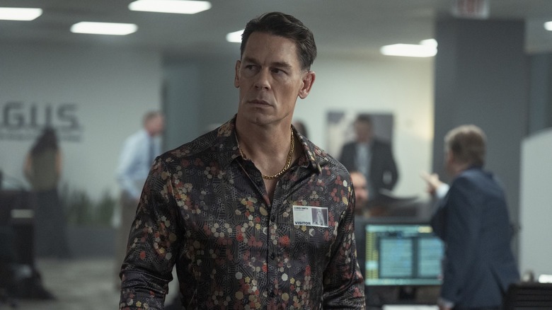 John Cena as Christopher Smith wearing a silk shirt in the alternate-ARGUS offices in Peacemaker season 2