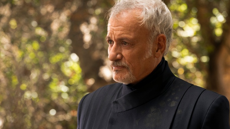 Q, who looks older, stands out in the woods in Star Trek: Picard