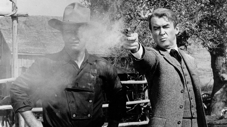 Jimmy Stewart shoots a gun next to John Wayne in the Man Who Shot Liberty Valance