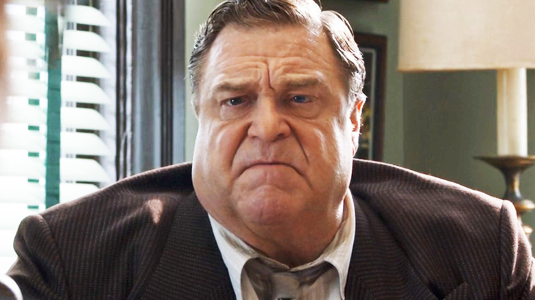 John Goodman's Frank King looks upset as he sits at his desk in Trumbo