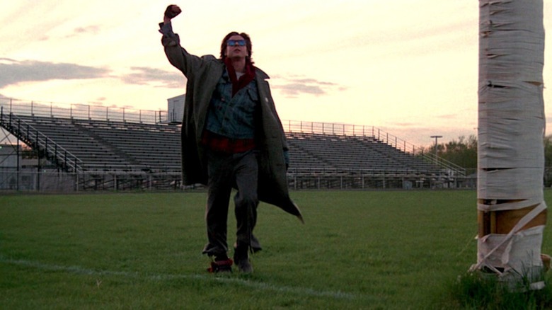 Judd Nelson pumps his fist on a football field as John Bender in The Breakfast Club