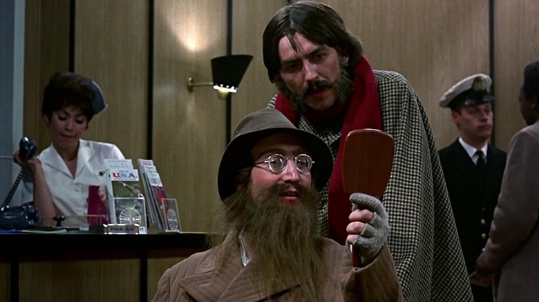 John Lennon wearing a fake beard and hat next to George Harrison in Help!