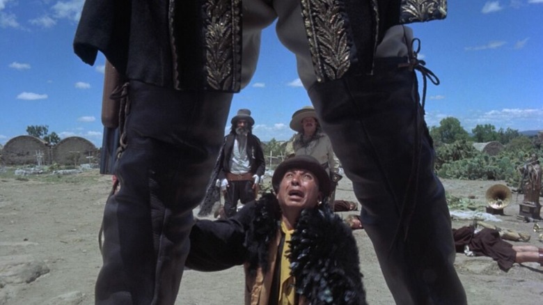 Un homme désespéré vu à travers les jambes d'El Topo dans El Topo