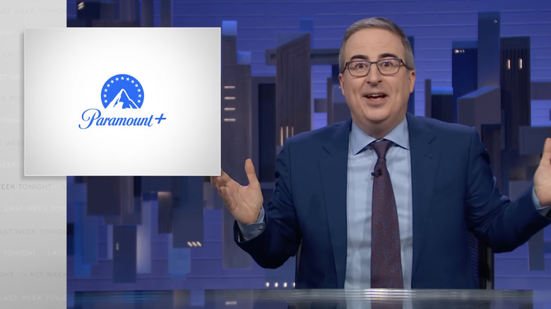 A befuddled John Oliver sits next to a Paramount logo on Last Week Tonight with John Oliver