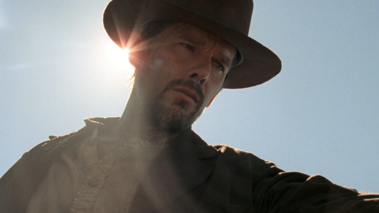 Ethan Hawke's Paul is seen in silhouette against the sun and a blue sky in In a Valley of Violence