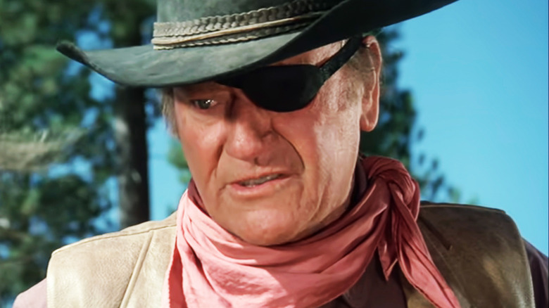 John Wayne's Rooster Cogburn looks down in closeup in Rooster Cogburn