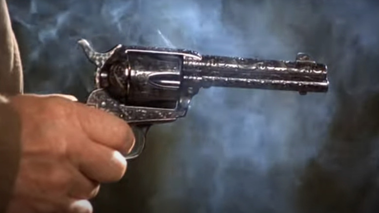 A hand holds a revolver in closeup in The Shootist