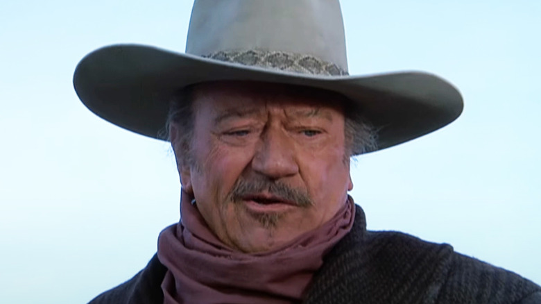 John Wayne's J. B. Books looks down against a blue sky in The Shootist