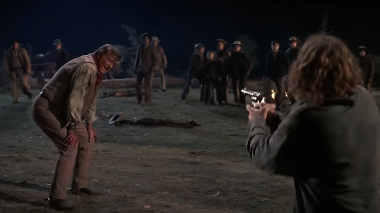 Bruce Dern's Asa Watts aims his gun at John Wayne's Wil Andersen in The Cowboys