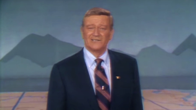 John Wayne stands looking into camera in Swing Out Sweet Land