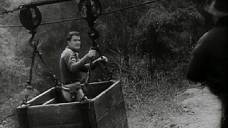 John Wayne as John Mason stands in a crate in Haunted Gold
