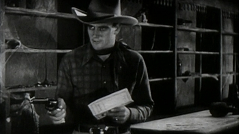 John Wayne as John Mason points his pistol in Haunted Gold