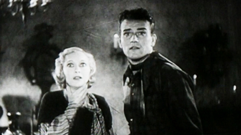 John Wayne as John Mason and Sheila Terry as Janet Carter look shocked as they stand side by side in Haunted Gold